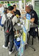Mehrere Personen stehen an einem Informationsstand bei einer Veranstaltung und betrachten Broschüren zu Ausbildungs- und Praktikumsmöglichkeiten.