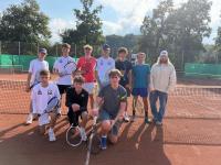 Gruppe junger Männer, Tennisspieler, die auf einem Lehmplatz mit Tennisschlägern posieren.