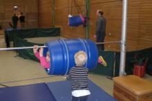 Ein Gymnastics-Trainingsbereich mit Hindernissen, Stangen und einem blauen Parcours.