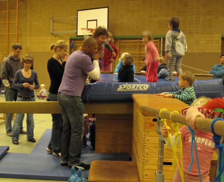 Gruppe von Kindern und Jugendlichen bei einer sportlichen Übung in einer Turnhalle