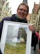 Ein Mann mit Brille steht im Freien und hält einen gerahmten Preis mit der Aufschrift Heimat-Preis 2019.