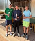 Drei junge Männer in Sportkleidung stehen zusammen und halten jeweils eine kleine Trophäe.