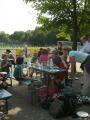 Eine Gruppe von Menschen sitzt und steht entspannt bei einem Sportevent im Freien.
