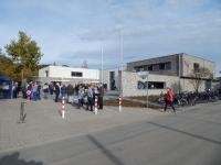 Ein moderner, eingeschossiger Gebäudekomplex mit einer großen, gepflasterten Vorfläche.