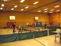 Eine Sporthalle mit Basketball- und Fußballmarkierungen, auf der mehrere Personen spielen und trainieren.