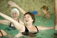Mehrere Personen entspannen und genießen einen Tag in einem Schwimmbecken oder Spa-Bereich.