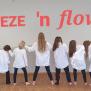 Eine Gruppe von Menschen, die in einer Reihe posieren und verschiedene Posen einnehmen, vor einem Hintergrund mit dem Schriftzug Freeze n flow.