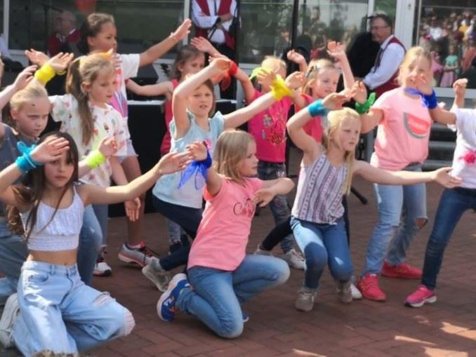 Eine große Gruppe von Kindern posiert fröhlich und ausgelassen im Freien.