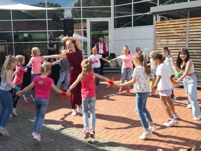 Eine Gruppe von Familien und Kindern versammelt sich bei einem festlichen Outdoor-Event.