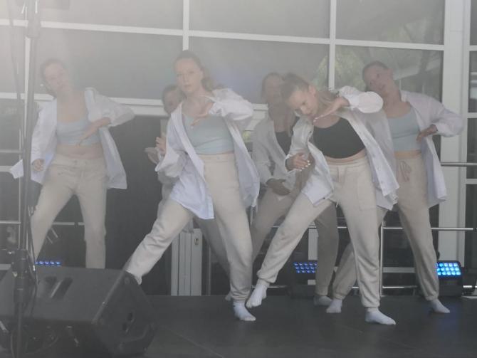 Eine Gruppe junger Frauen führt eine Choreografie auf einer Bühne auf.