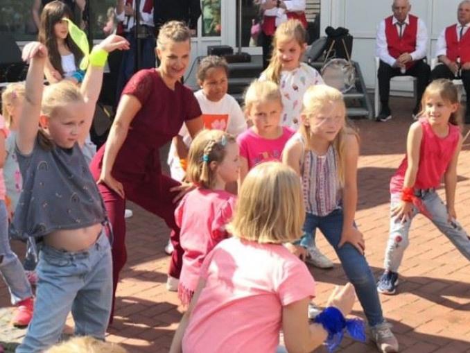 Eine große Gruppe von Kindern und Erwachsenen versammelt sich draußen bei einem Treffen.