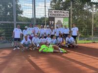 Eine Gruppe junger Männer steht auf einem Tennisplatz vor einem Vereinsnamen-Schild.